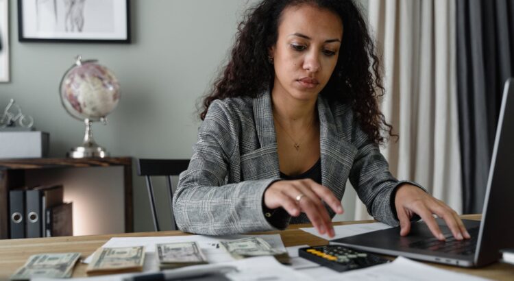 A Woman in Plaid Blazer Using Her Laptop and Mobile Phone