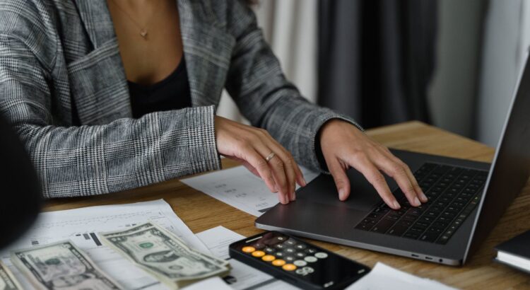 A Woman in Plaid Blazer Using Her Laptop