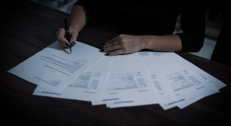 a woman sitting at a table with lots of papers